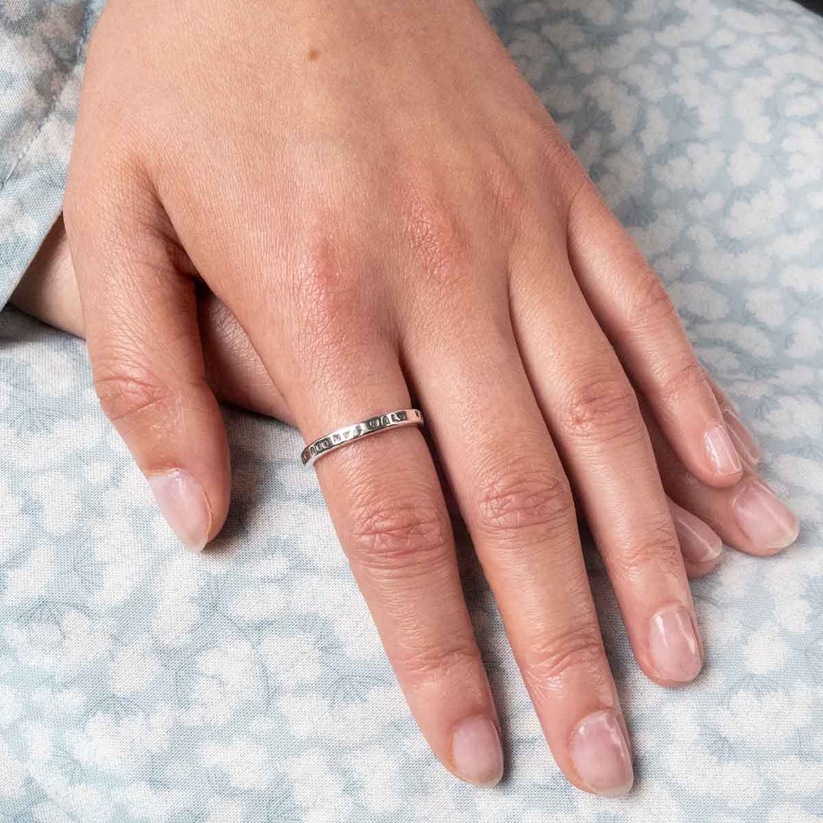 'Half Agony, Half Hope' Ring on a finger resting on a regency dress.